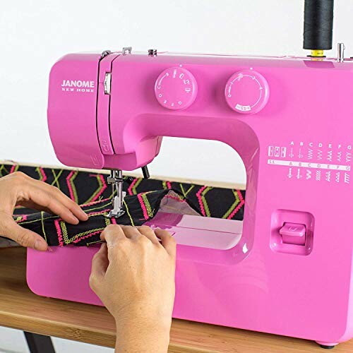 Person using a pink sewing machine with fabric