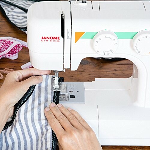 Person sewing fabric with a Janome sewing machine.